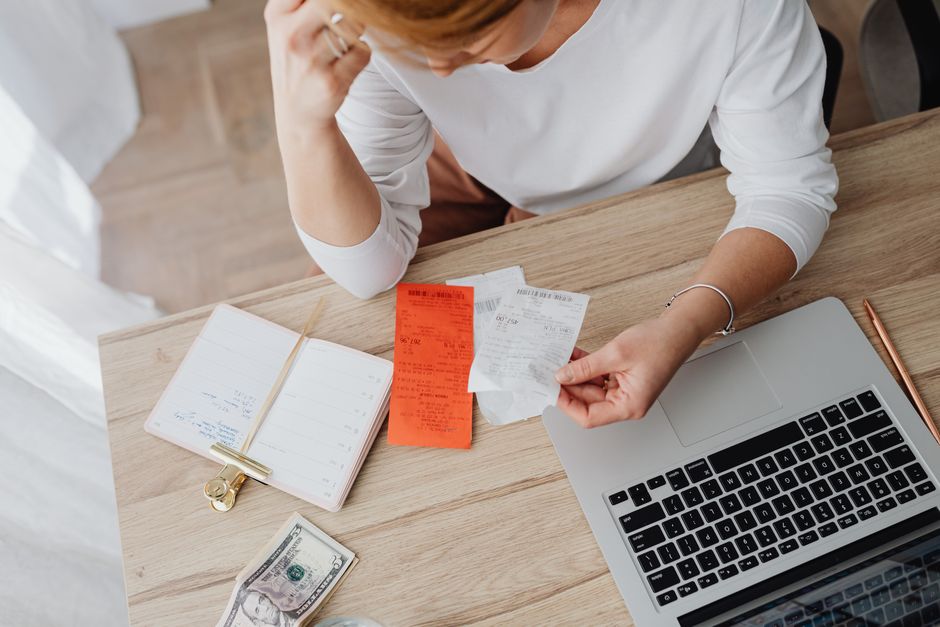 Person reviewing receipts at a laptop